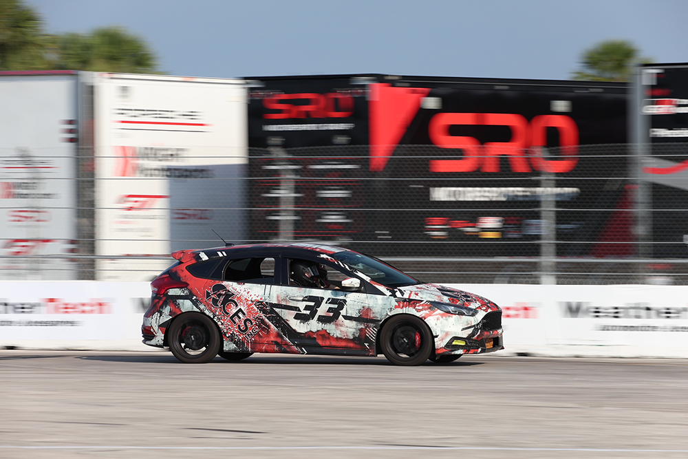 An image of a racecar with a vehicle wrap with the word ACES on it.